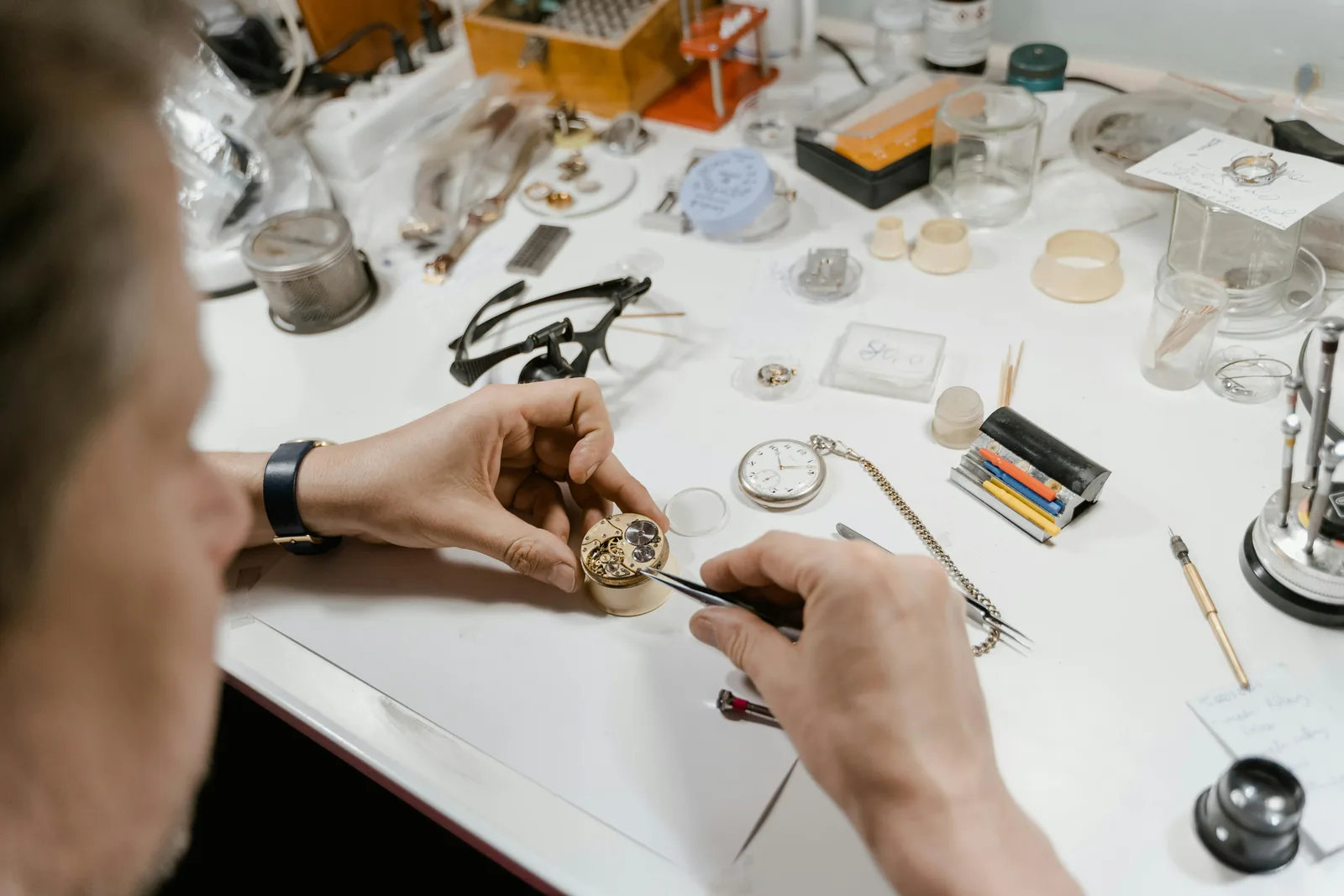 Eye-level view of a luxury watchmaker’s bench with tools and a classic wristwatch